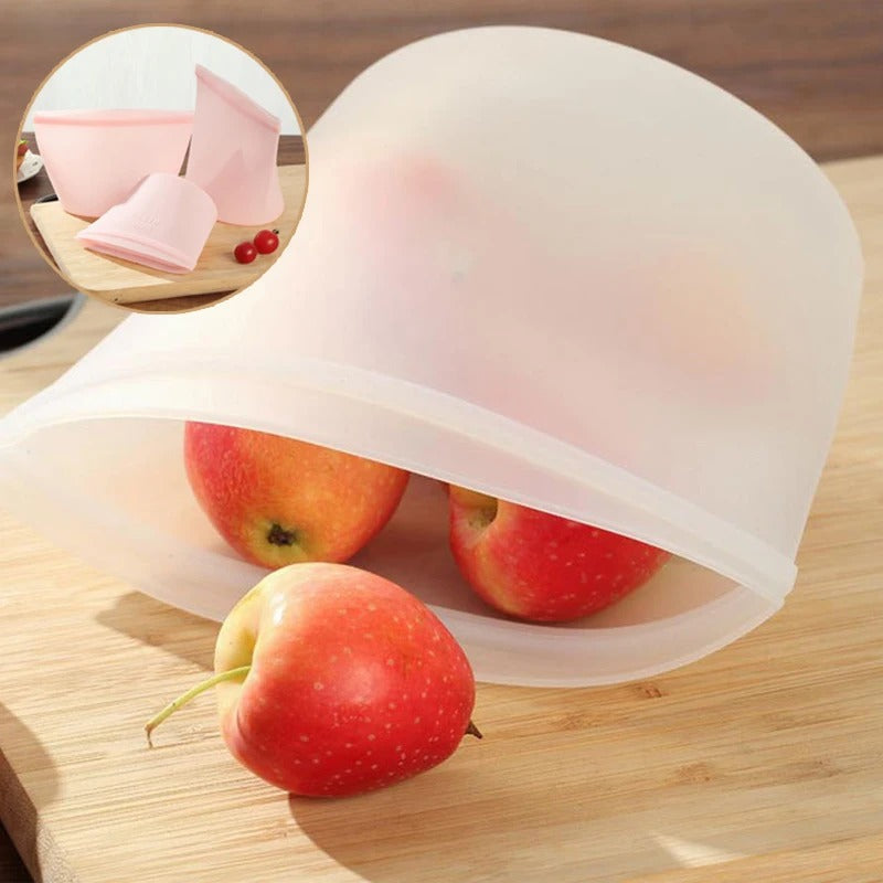 Open white silicone bag holding apples on a wooden surface