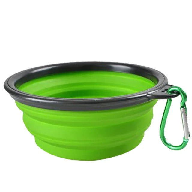 Foldable green pet food bowl with carabiner, convenient for travel and outdoor use.