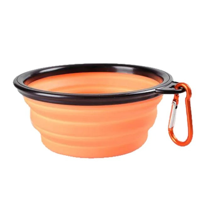 Bright orange collapsible pet food bowl with clip for easy carrying and storage.