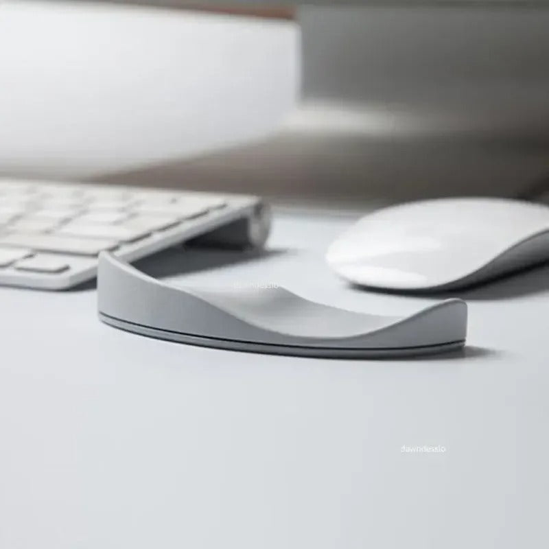 Sleek ergonomic wrist rest pad on a clean office desk with a wireless keyboard and mouse.