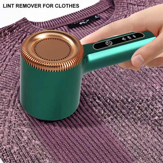 Hand using green fabric shaver to remove lint from a purple sweater
