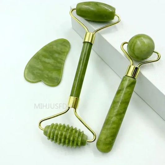 Close-up of jade roller set with smooth and textured rollers alongside a Gua Sha stone.