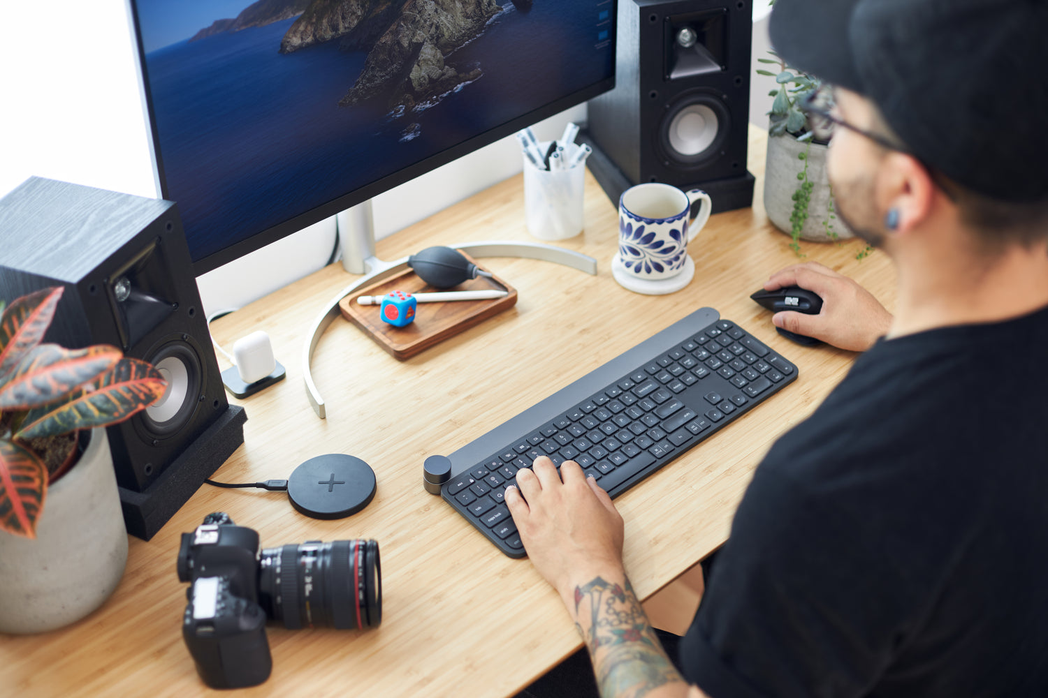 Modern workspace setup with computer, camera, and coffee mug, symbolizing the passion and dedication behind Deal Source Online's journey